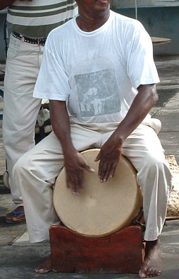 Musicien jouant du maloya avec un roulèr, tambour traditionnel réunionnais